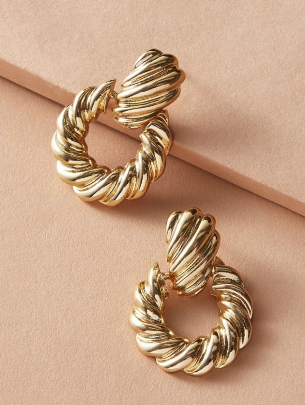 Gold dangle doorknocker earrings; one sided
